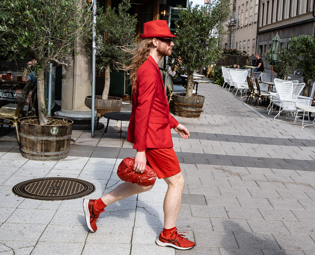 Man with a large white beard wearing a black suit and black hat.